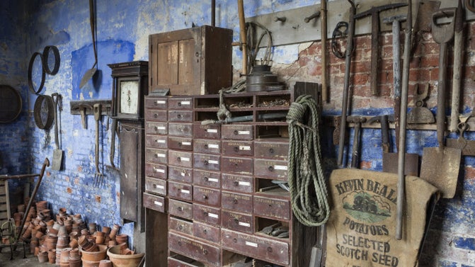 A room filled with hanging gardening tools, flower pots and other gardening equipment.